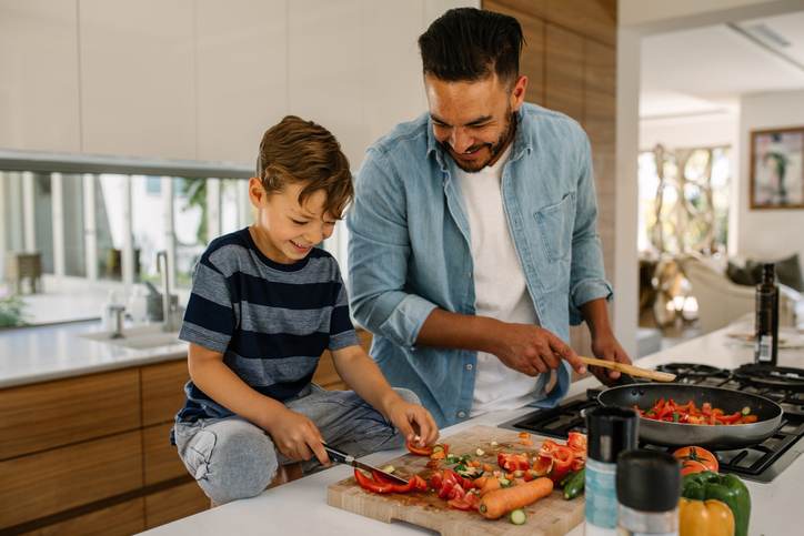 Father and son preparing food in kitchen